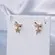 Brinco Pequeno Lacinho Navete com Pingente Estrelinha Cravejada em Zircônias Banhado a Ouro 18K