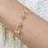 Pulseira Infantil com Pingentes de Lacinhos e Menininha Banhada a Ouro 18k  – Doçura e Delicadeza